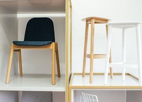 Abstract interior of room with white wall and various chairs placed in boxes and near each other
